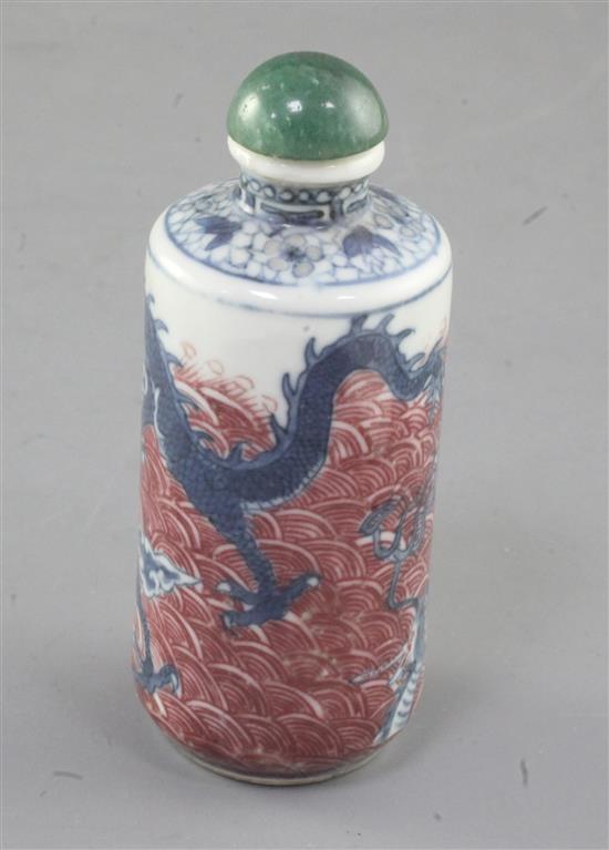 A Chinese underglaze blue and copper red dragon cylindrical snuff bottle, 19th century, height 8cm excl. stopper